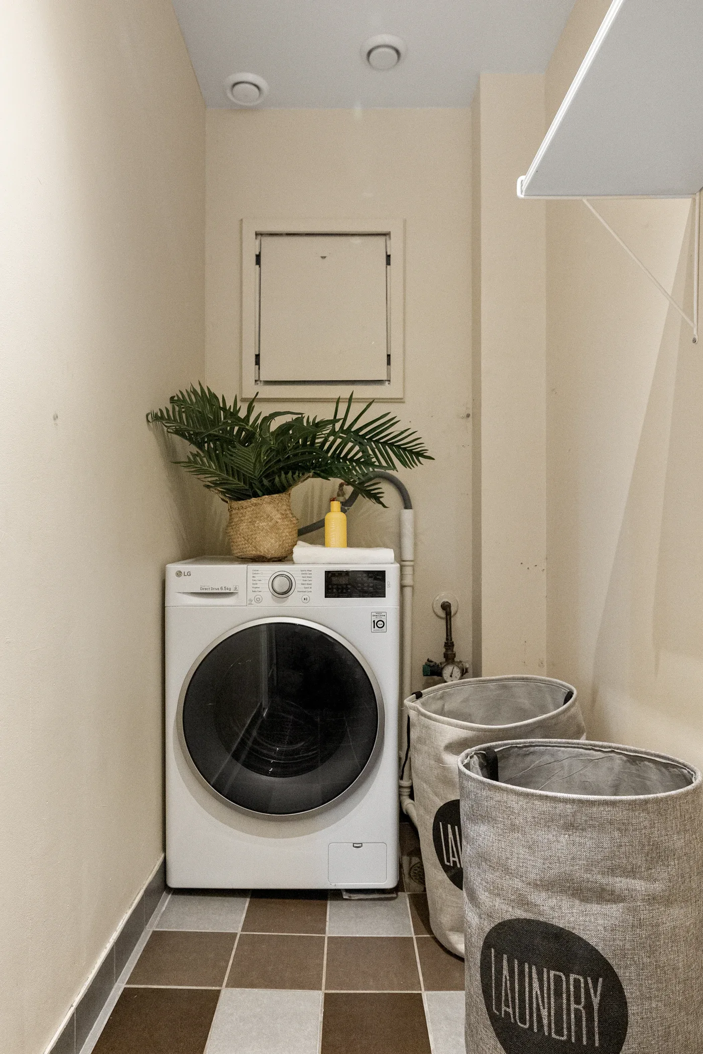 Laundry nook with a washing machine, plant, and sorting baskets