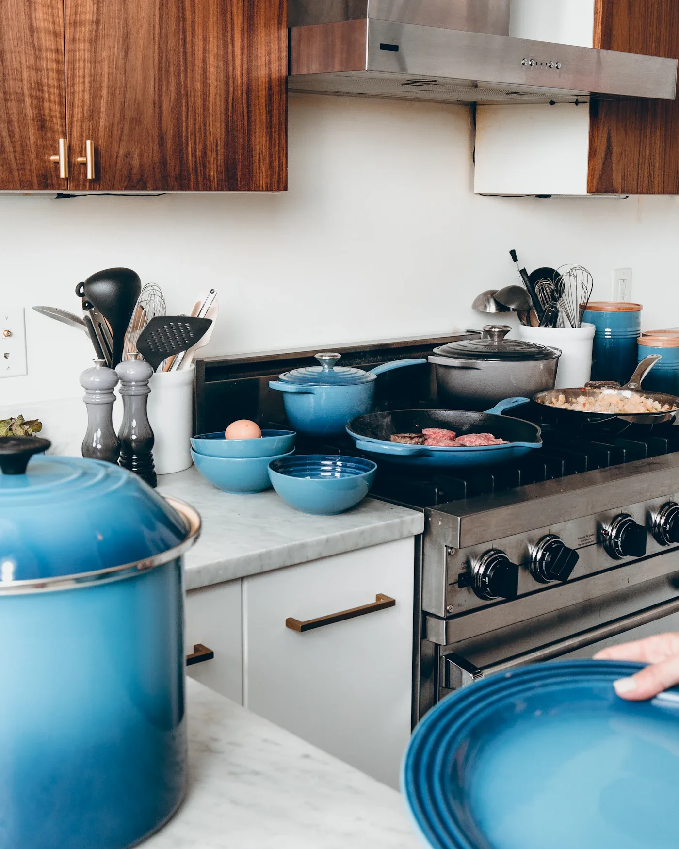 Blue cookware and tableware arranged around a kitchen range
